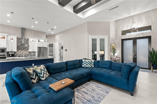 living room featuring visible vents, recessed lighting, a towering ceiling, and french doors