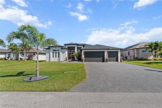 prairie-style home featuring stucco siding, decorative driveway, a front lawn, and an attached garage