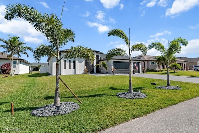 view of front of house featuring a front yard, driveway, stucco siding, and an attached garage