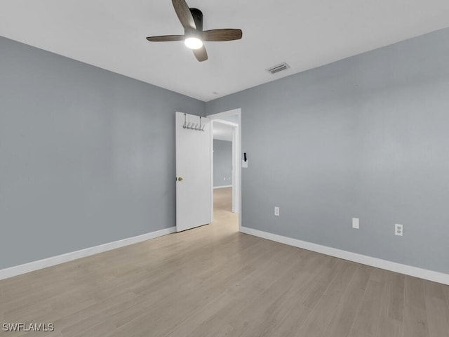 spare room with a ceiling fan, wood finished floors, and baseboards