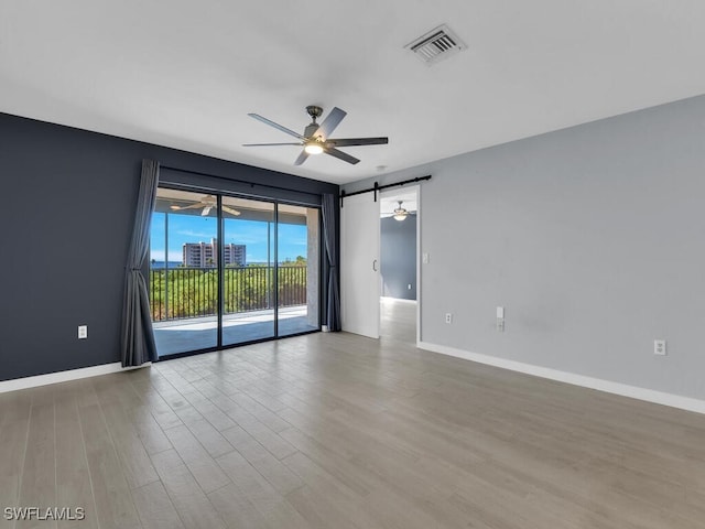 unfurnished room with a ceiling fan, wood finished floors, and baseboards