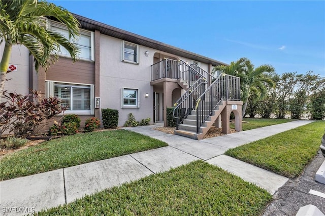 25100 Sandhill Blvd Unit 103, Punta Gorda, FL 33983 - view of front of home with a front yard, stairway, and stucco siding