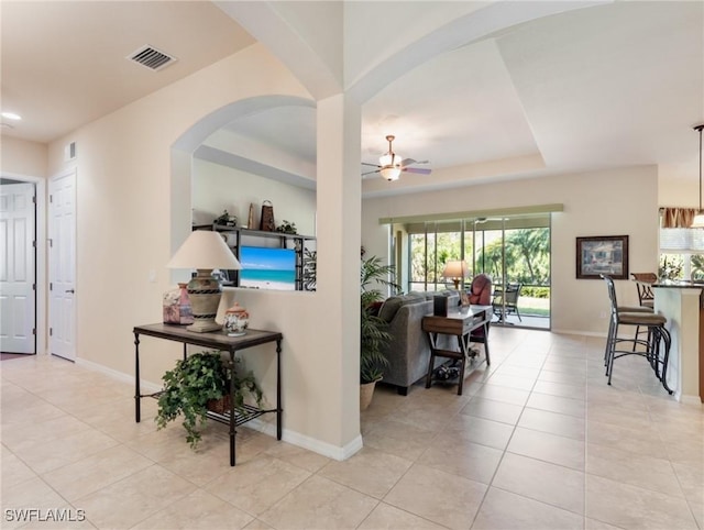 21826 Bella Terra Blvd, Estero, FL 33928 - tiled living area featuring a ceiling fan, a tray ceiling, baseboards, and visible vents