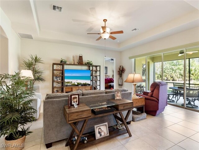 21826 Bella Terra Blvd, Estero, FL 33928 - living room featuring a tray ceiling, visible vents, light tile patterned flooring, and ceiling fan