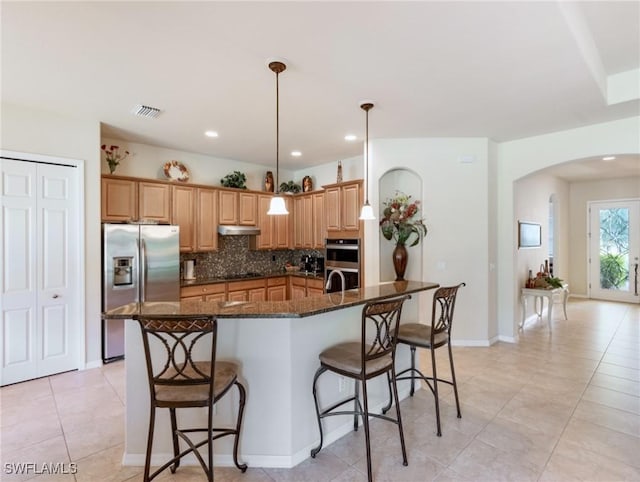 21826 Bella Terra Blvd, Estero, FL 33928 - kitchen featuring visible vents, stainless steel appliances, arched walkways, under cabinet range hood, and a breakfast bar area