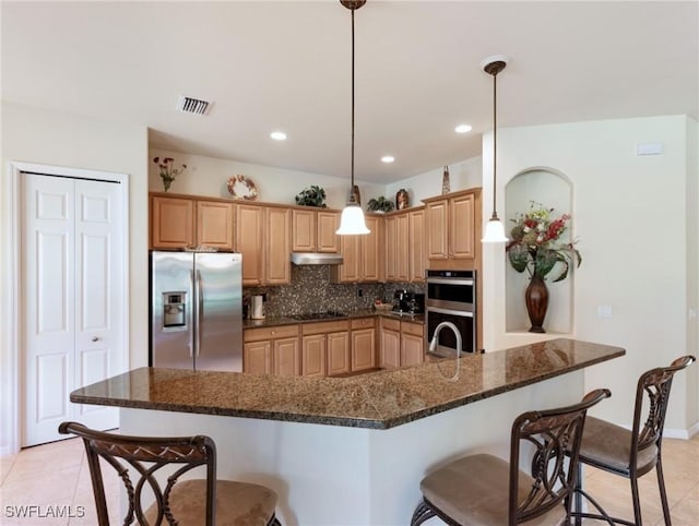 21826 Bella Terra Blvd, Estero, FL 33928 - kitchen featuring visible vents, a kitchen bar, appliances with stainless steel finishes, under cabinet range hood, and backsplash