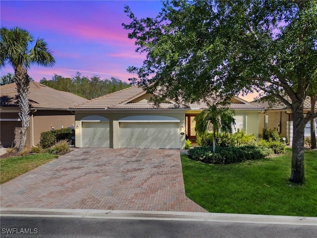 21826 Bella Terra Blvd, Estero, FL 33928 - view of front facade featuring decorative driveway, a tile roof, stucco siding, and a yard
