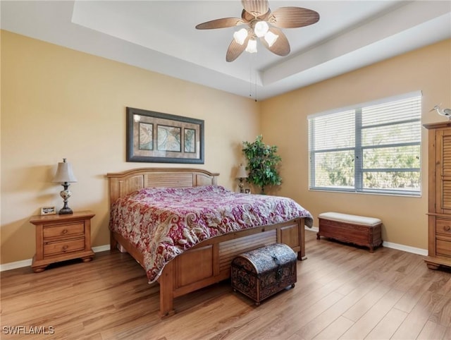 21826 Bella Terra Blvd, Estero, FL 33928 - bedroom with a raised ceiling, baseboards, ceiling fan, and light wood-type flooring