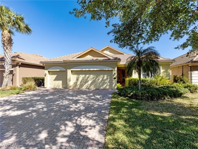 21826 Bella Terra Blvd, Estero, FL 33928 - view of front of property featuring a tiled roof, decorative driveway, stucco siding, and an attached garage