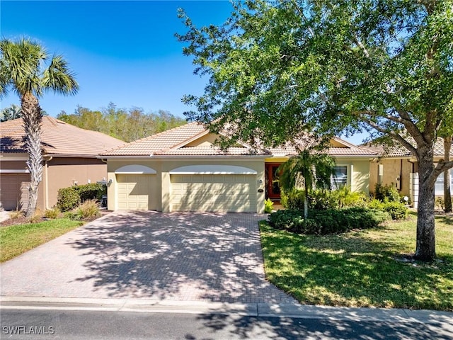 21826 Bella Terra Blvd, Estero, FL 33928 - view of front facade featuring a tiled roof, driveway, stucco siding, and an attached garage