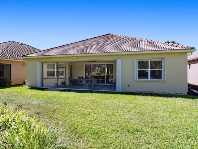 21826 Bella Terra Blvd, Estero, FL 33928 - rear view of house featuring stucco siding, a tile roof, and a lawn