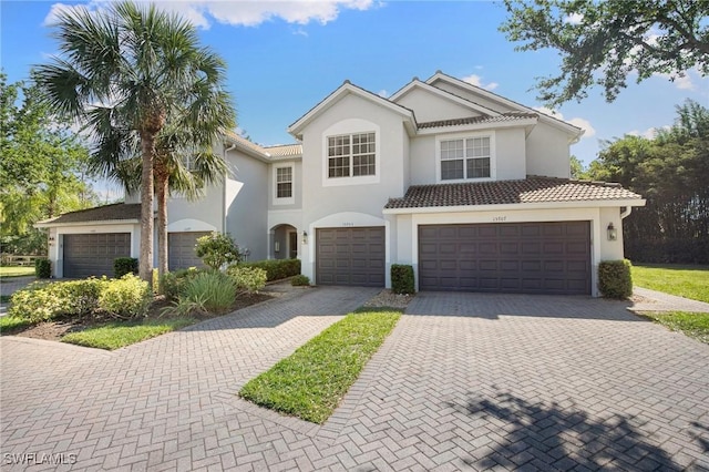 15703 Marcello Cir, Naples, FL 34110 - view of front facade with stucco siding, a tile roof, decorative driveway, and a garage