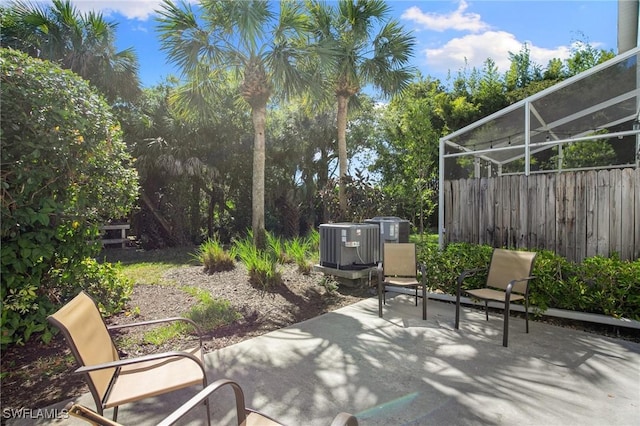 15703 Marcello Cir, Naples, FL 34110 - view of patio / terrace featuring a lanai, central air condition unit, and fence