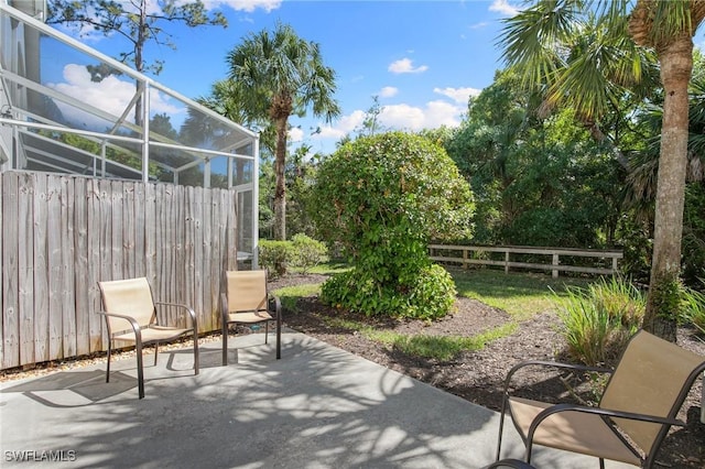 15703 Marcello Cir, Naples, FL 34110 - view of patio / terrace featuring glass enclosure and fence