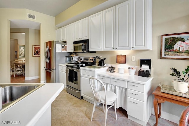 96 Vivante Blvd Unit 211, Punta Gorda, FL 33950 - kitchen with stainless steel appliances, white cabinets, light countertops, and light tile patterned floors