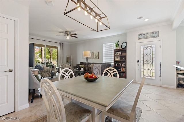 dining area with light tile patterned floors, crown molding, visible vents, baseboards, and ceiling fan