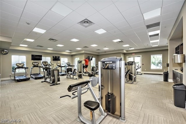 exercise room with light colored carpet, baseboards, visible vents, and a drop ceiling