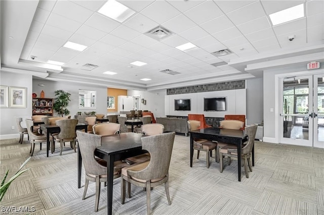 dining space featuring french doors, visible vents, light carpet, a wealth of natural light, and baseboards