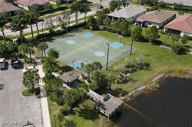 view of basketball court with a lawn, a water view, a residential view, and community basketball court