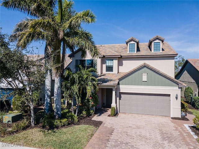 view of front facade featuring a garage, driveway, and stucco siding