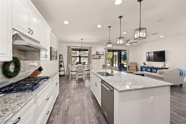 kitchen featuring dark wood-type flooring, under cabinet range hood, ornamental molding, appliances with stainless steel finishes, and a sink