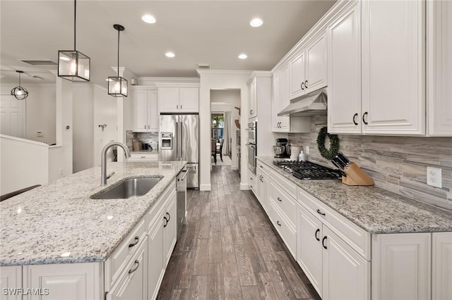 kitchen with under cabinet range hood, white cabinets, appliances with stainless steel finishes, and a sink