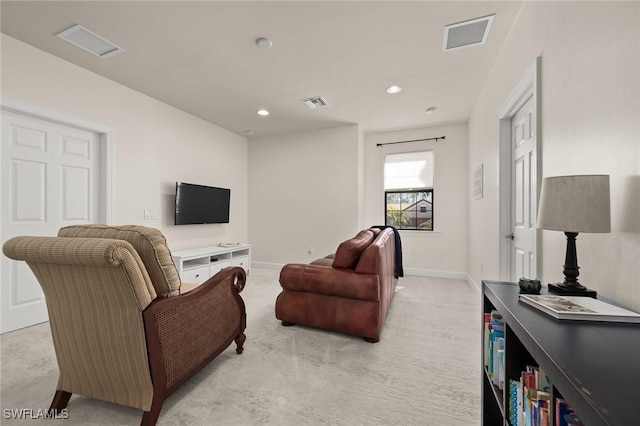 living area featuring visible vents, light colored carpet, and baseboards