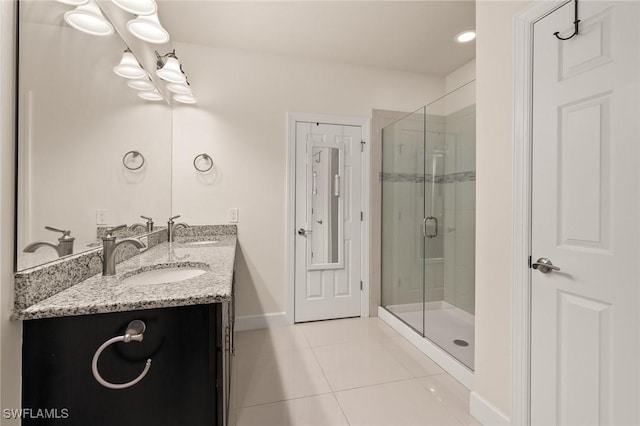 full bathroom featuring a sink, a stall shower, double vanity, and tile patterned flooring