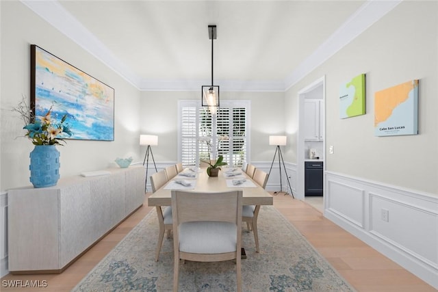 9119 Links Dr, Fort Myers, FL 33913 - dining space featuring a decorative wall, crown molding, light wood-type flooring, and wainscoting