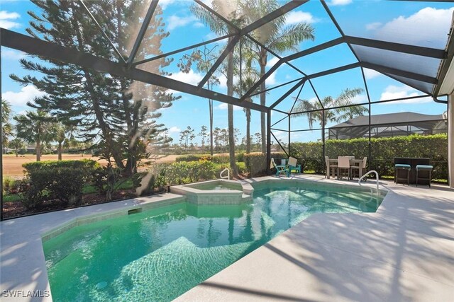 9119 Links Dr, Fort Myers, FL 33913 - view of pool featuring glass enclosure, a pool with connected hot tub, and a patio