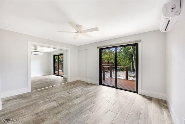 unfurnished room featuring a wall mounted AC, ceiling fan, and a wealth of natural light
