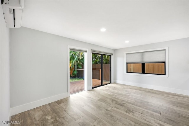 spare room with wood finished floors, baseboards, and recessed lighting