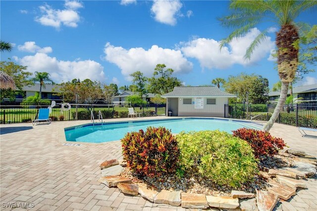 1232 Commonwealth Cir Unit P103, Naples, FL 34116 - community pool featuring a patio, fence, and an outbuilding
