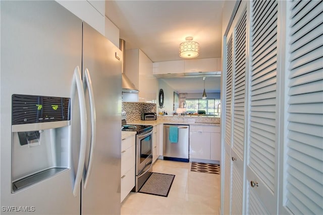 1232 Commonwealth Cir Unit P103, Naples, FL 34116 - kitchen featuring modern cabinets, ventilation hood, appliances with stainless steel finishes, white cabinets, and decorative backsplash