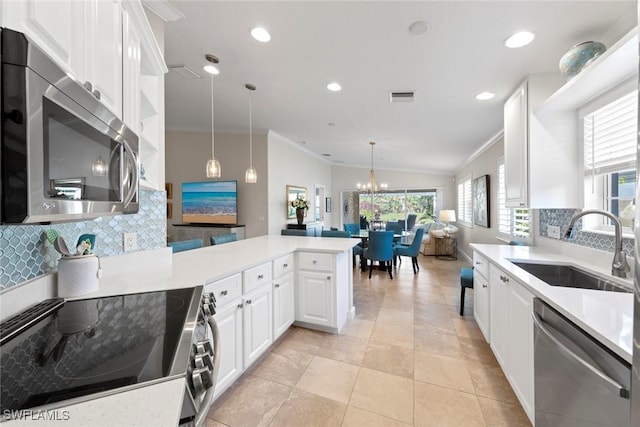 28970 Vermillion Ln, Bonita Springs, FL 34135 - kitchen featuring stainless steel appliances, a sink, ornamental molding, a peninsula, and decorative backsplash
