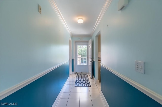 doorway with baseboards, light tile patterned floors, and crown molding
