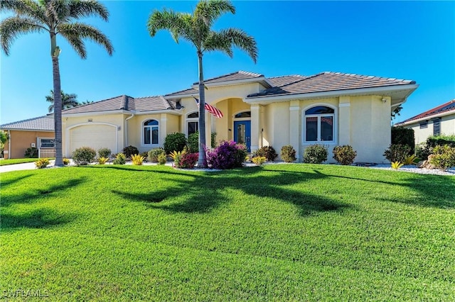 1368 Grebe Dr, Punta Gorda, FL 33950 - mediterranean / spanish-style house with a front lawn, an attached garage, and stucco siding