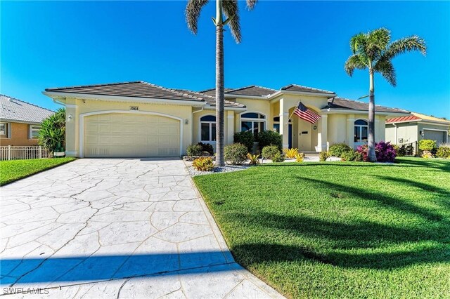 1368 Grebe Dr, Punta Gorda, FL 33950 - mediterranean / spanish-style house with stucco siding, fence, concrete driveway, a front yard, and an attached garage
