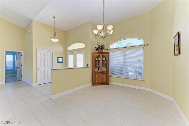 1368 Grebe Dr, Punta Gorda, FL 33950 - empty room with light tile patterned floors, a notable chandelier, high vaulted ceiling, and baseboards