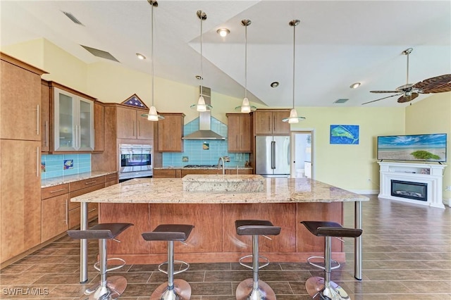 1368 Grebe Dr, Punta Gorda, FL 33950 - kitchen with brown cabinetry, visible vents, appliances with stainless steel finishes, wall chimney range hood, and backsplash