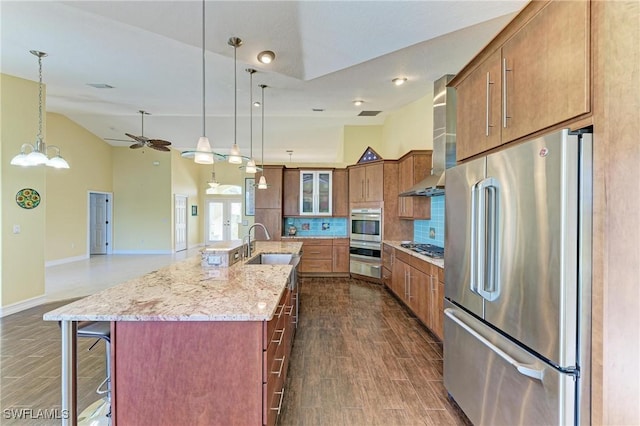 1368 Grebe Dr, Punta Gorda, FL 33950 - kitchen featuring tasteful backsplash, stainless steel appliances, wall chimney exhaust hood, ceiling fan, and wood tiled floor