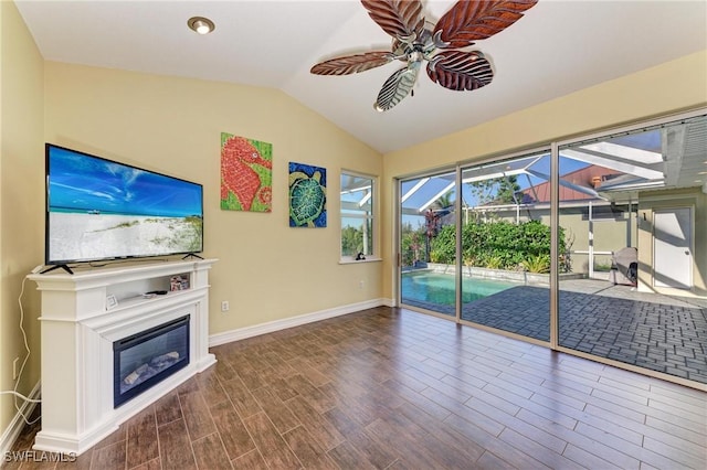 1368 Grebe Dr, Punta Gorda, FL 33950 - unfurnished living room with wood finished floors, lofted ceiling, a sunroom, ceiling fan, and a glass covered fireplace