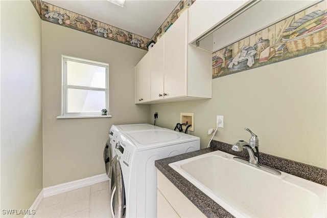 1368 Grebe Dr, Punta Gorda, FL 33950 - clothes washing area featuring a sink, washing machine and dryer, cabinet space, light tile patterned floors, and baseboards