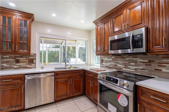 209 Pinehurst Cir, Naples, FL 34113 - kitchen with light countertops, a sink, stainless steel appliances, and light tile patterned flooring
