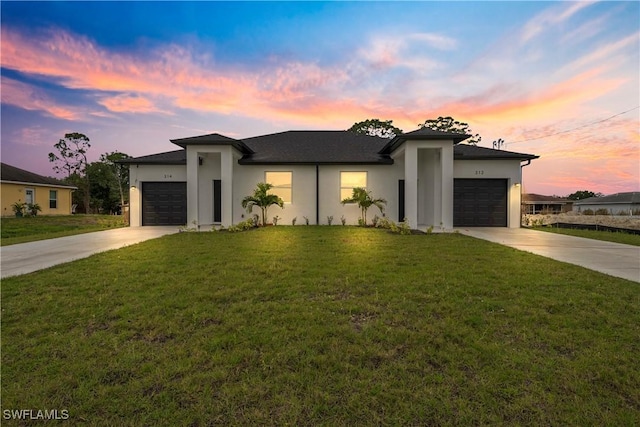 prairie-style house with driveway, an attached garage, and stucco siding