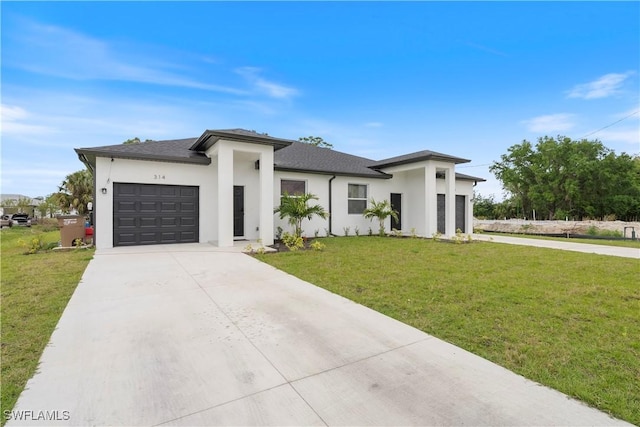 prairie-style home with a front yard, stucco siding, an attached garage, and concrete driveway