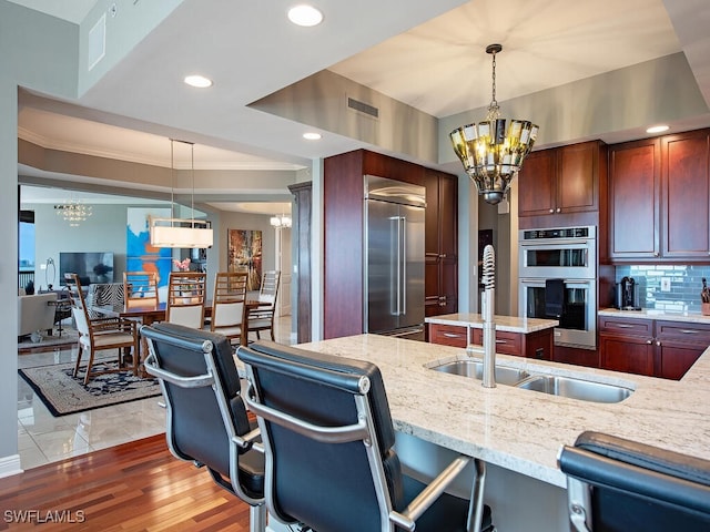 5051 Pelican Colony Blvd Unit 301, Bonita Springs, FL 34134 - kitchen featuring light stone countertops, visible vents, stainless steel appliances, and a notable chandelier