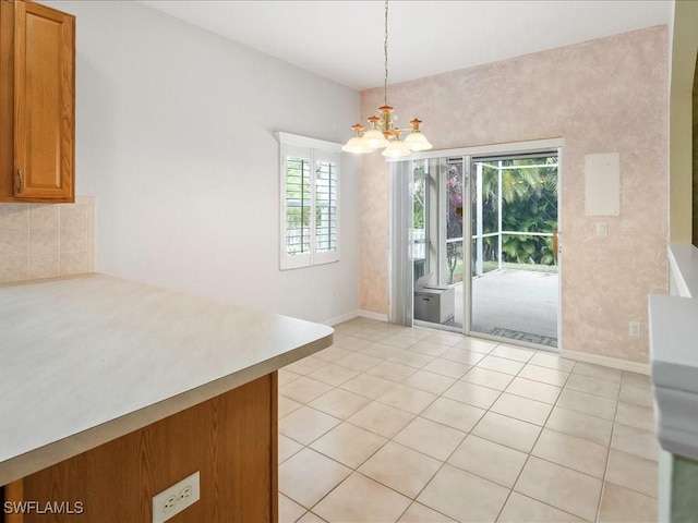 unfurnished dining area with light tile patterned floors, a chandelier, and baseboards