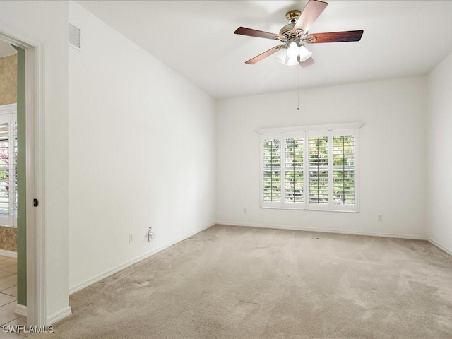 empty room with baseboards, visible vents, ceiling fan, and carpet flooring