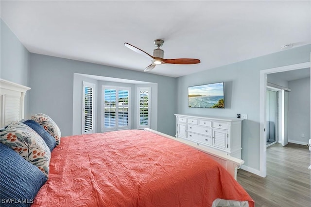 bedroom featuring baseboards, a ceiling fan, and wood finished floors